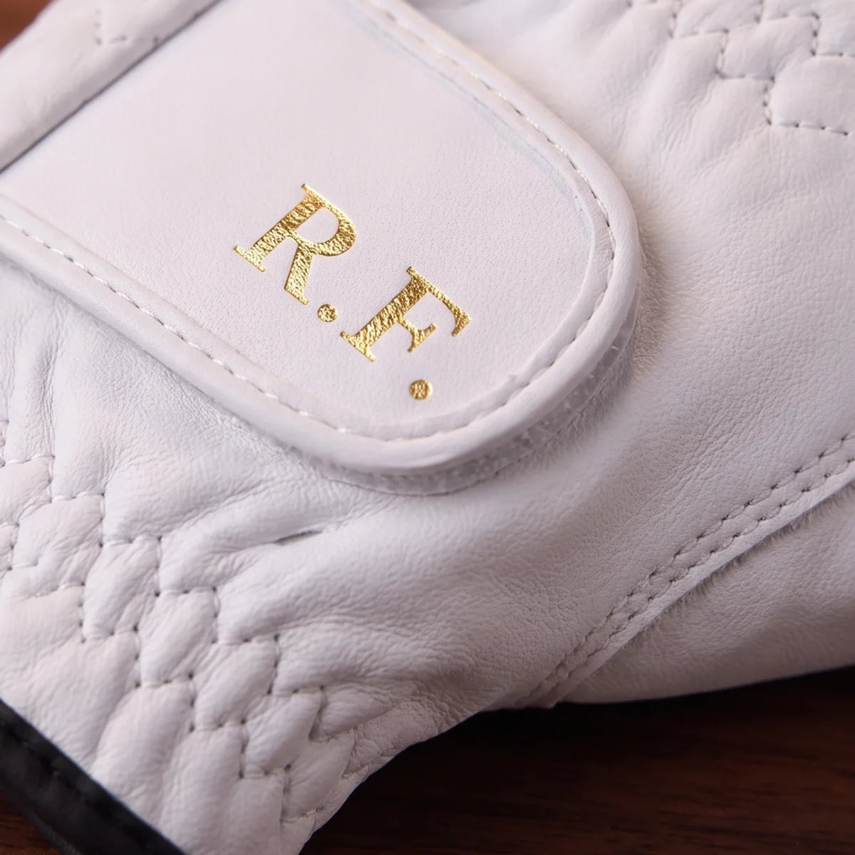 Gold foil initials pressed into the wrist tab